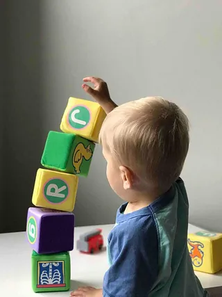 Ein Kind stapelt Bauklötze