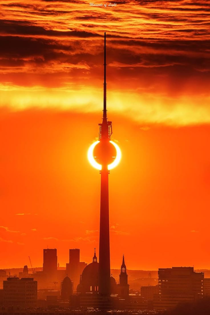 Menschen sitzen in einer großen Halle im Kerzenlicht; zwei Personen entzünden ihre Kerzen aneinander, um das Licht weiterzugeben
