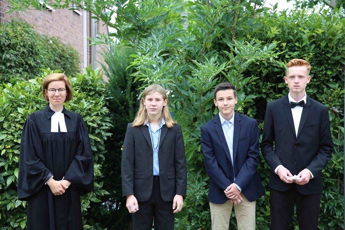 Pfarrerin Kraski mit Hitdorfer Konfirmanden vor einer Gartenszene